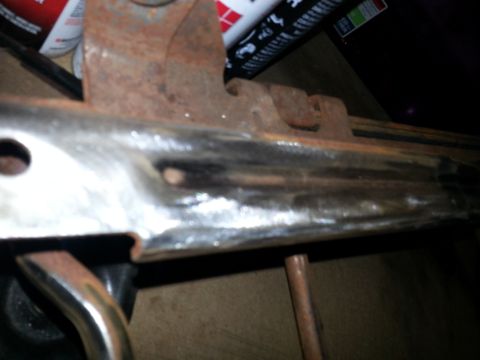 1994 Ford Bronco - A close-up view of a rusty seat bracket, likely from an older vehicle, showing signs of wear and tear.