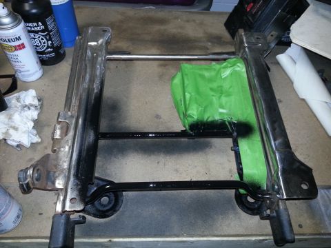 1994 Ford Bronco - A vehicle seat frame is shown with some parts taped off, possibly for painting.