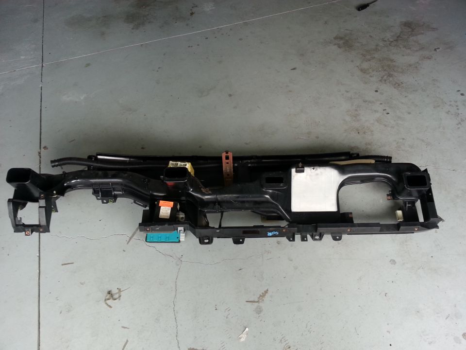 Black plastic dashboard frame with air vents and electrical connectors