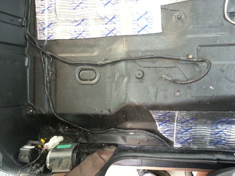 1994 Ford Bronco - Underside of vehicle interior showing floor pan, wiring harness, and sound insulation.