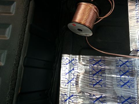 1994 Ford Bronco - Sound deadening material and a spool of copper wire are visible in the cargo area of a vehicle.