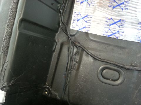 1994 Ford Bronco - Sound deadening material being installed on the floor pan of a 1994 Ford Bronco interior.