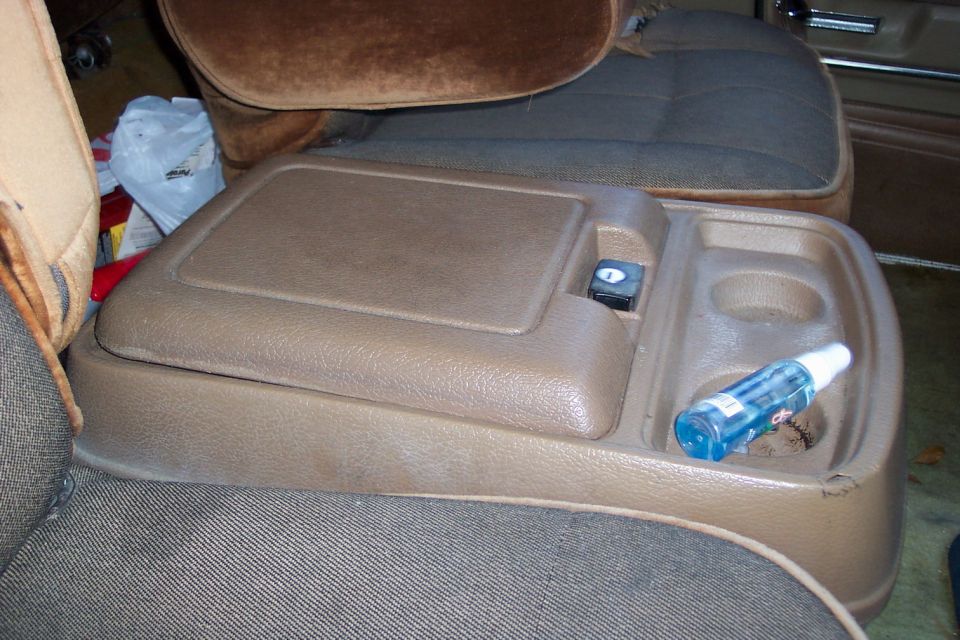 Tan removable center console with cup holders between cloth truck seats