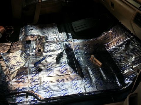 1994 Ford Bronco - Car interior floor being treated with sound deadening material, with tools laid out.