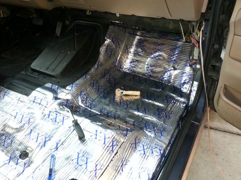 1994 Ford Bronco - Sound deadening material is being installed on the interior floor of a vehicle, with tools present.