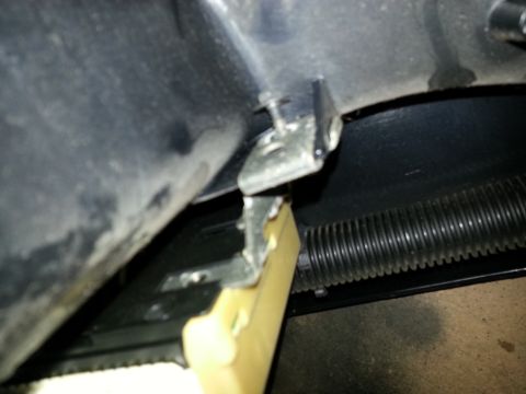 1994 Ford Bronco - A close-up view of an interior car part, showing a metal bracket and a yellow plastic component.