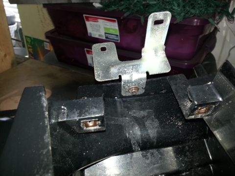 1994 Ford Bronco - Close-up of a metal bracket attached to a black plastic component, likely from a vehicle's dashboard.
