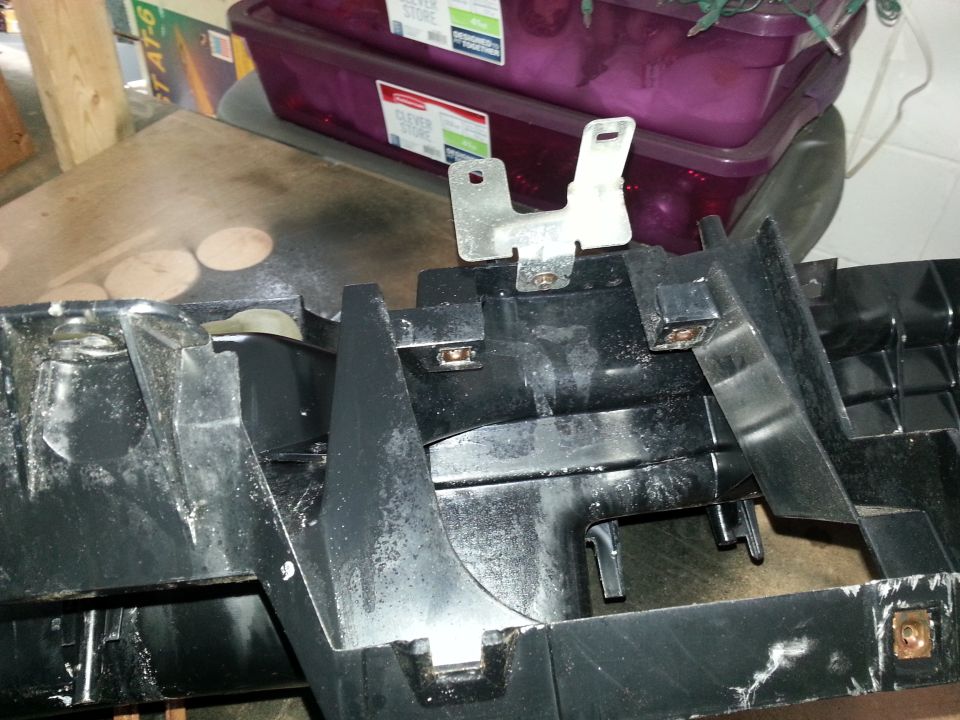 Black plastic dashboard component with metal bracket attached