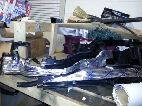 1994 Ford Bronco - A disassembled car dashboard part covered in insulation sits on a workbench.