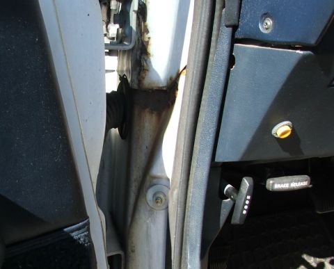 1988 Ford Crown Victoria LTD - Close-up of the interior door jamb and dashboard, showing rust and a brake release lever.