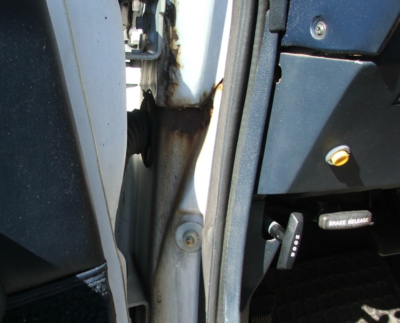 Interior door jamb with rust and dashboard with brake release lever