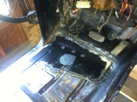 1979 Ford Bronco - The floor of a vehicle's interior shows recent welding work and exposed electrical components.