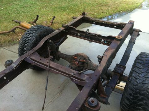1979 Ford Bronco - Frame and suspension parts of a vehicle, likely undergoing restoration or disassembly.
