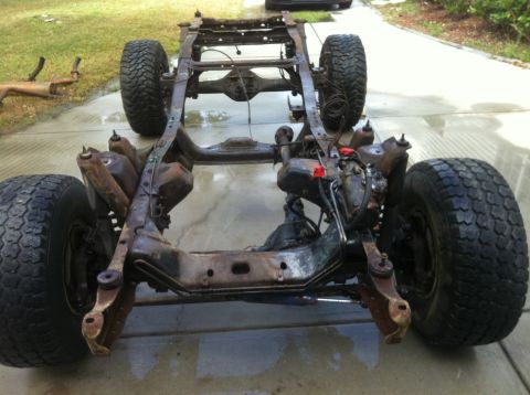 1979 Ford Bronco - The chassis and suspension components of a vehicle are shown, with tires attached.