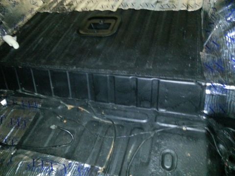 1994 Ford Bronco - The floor of a vehicle interior, showing sound deadening and exposed wiring.