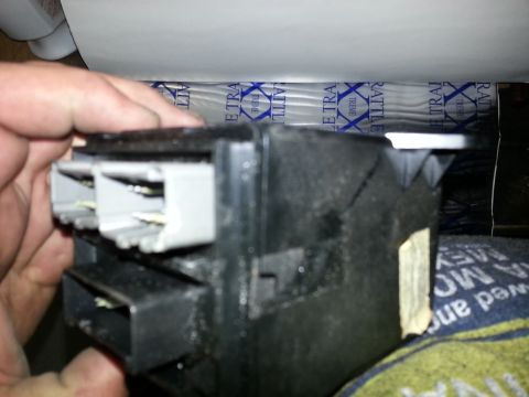 1994 Ford Bronco - A hand holds a black plastic electrical connector with multiple gray plug-in ports.