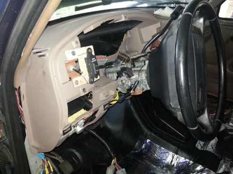 1994 Ford Bronco - The interior of a vehicle shows a partially disassembled dashboard with exposed wiring and components.