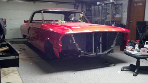 1964 Ford Fairlane - A red 1964 Ford Fairlane coupe is shown in a garage, appearing to be in the process of restoration with its front end disassembled.