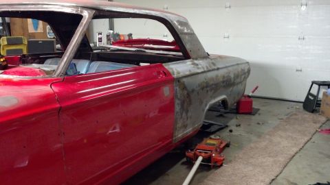 1964 Ford Fairlane - A 1964 Ford Fairlane coupe body is undergoing restoration in a garage, showing both red paint and bare metal sections.