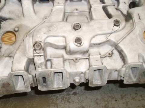 1967 Ford Mustang - Engine intake manifold shown from the side, detailing its cast metal construction.