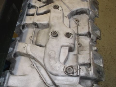 1967 Ford Mustang - This is a close-up view of a cast metal engine block, showing its intricate design and mounting hardware.