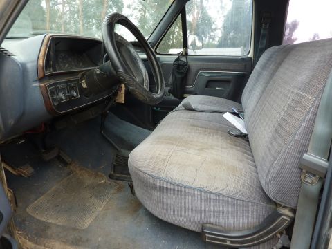 1991 Ford F-350 - The interior of a 1991 Ford F-350 shows a worn bench seat and dashboard.