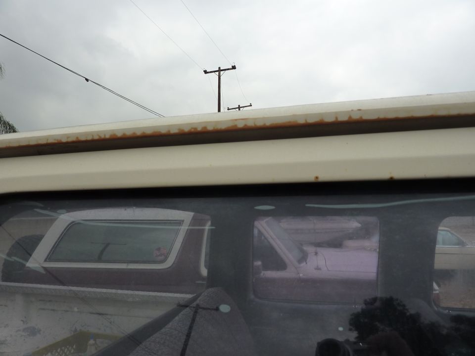 View through a truck's side window showing another vehicle and part of a truck bed