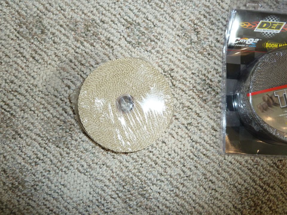 Roll of exhaust wrap and its packaging on a carpeted surface