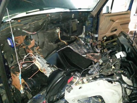 1994 Ford Bronco - The interior of a vehicle is in a state of disassembly, revealing its internal components and wiring.