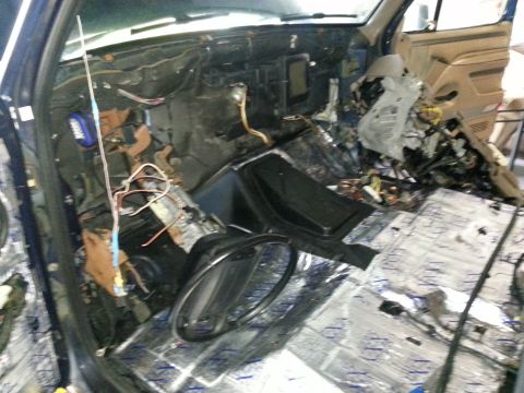 1994 Ford Bronco - The interior of a vehicle is shown with the dashboard disassembled, revealing wiring and insulation.