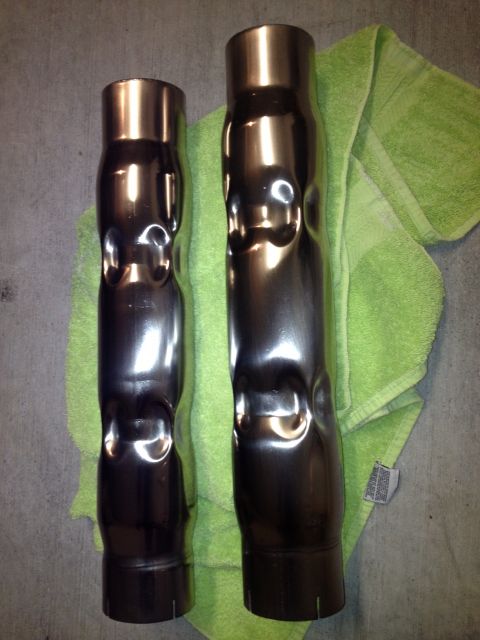 2013 Ford Mustang - Two exhaust pipes, one larger than the other, are laid out on a green towel.