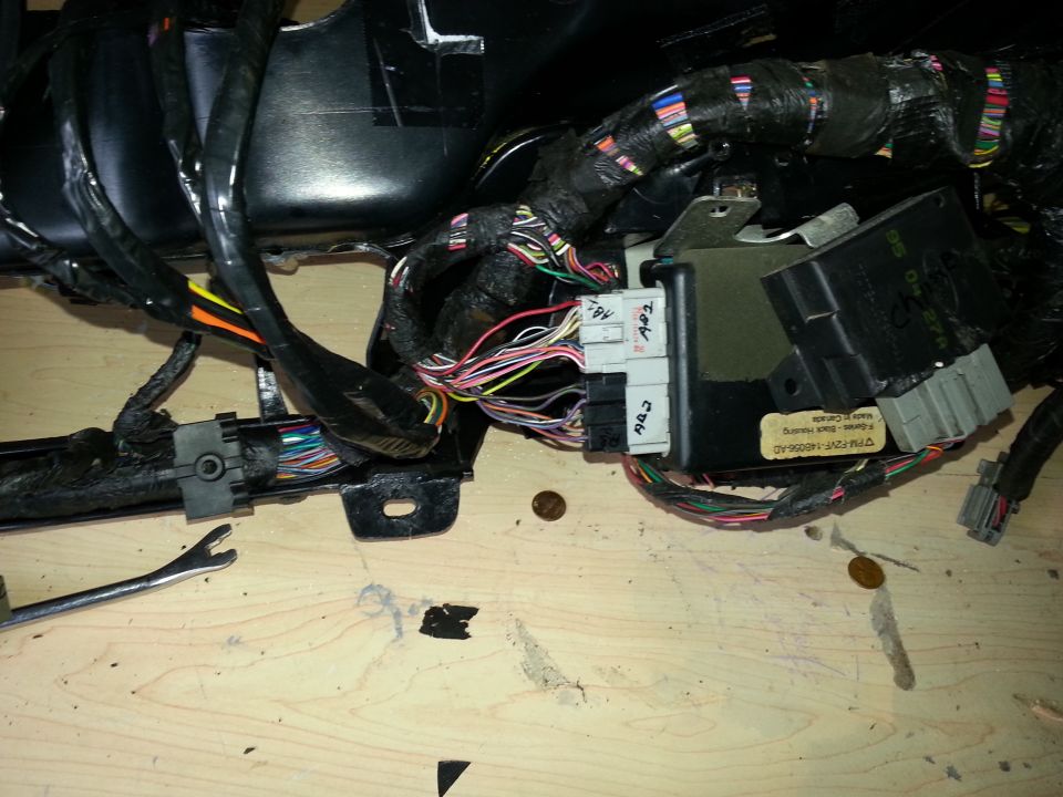 Vehicle wiring harness with multiple connectors and black control modules. Some connectors are labeled