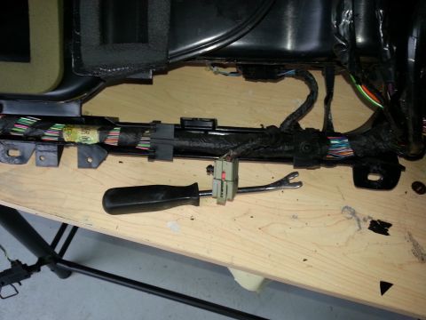 1994 Ford Bronco - Close-up of a vehicle's interior wiring harness, with tools laid out on a workbench.
