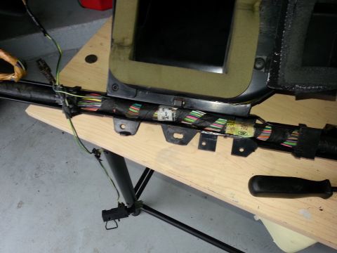 1994 Ford Bronco - Close-up of a vehicle's dashboard wiring harness, showing numerous colorful wires and connectors laid out on a wooden surface.