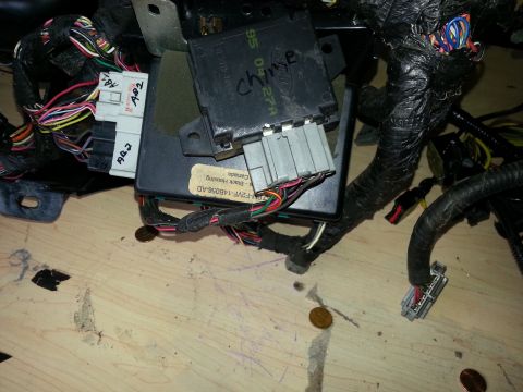 1994 Ford Bronco - Close-up of a complex automotive wiring harness and a control module, likely from a vehicle's dashboard.