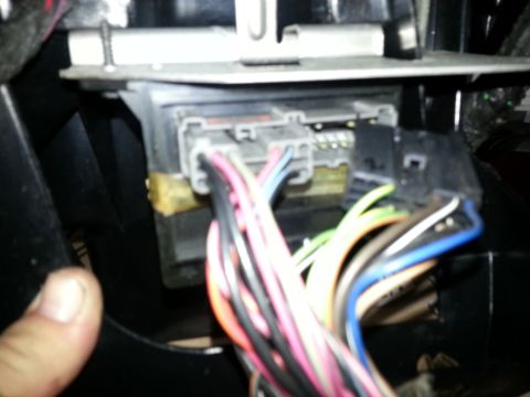 1994 Ford Bronco - A close-up view of a vehicle's interior wiring harness connector, showing a bundle of multicolored wires.