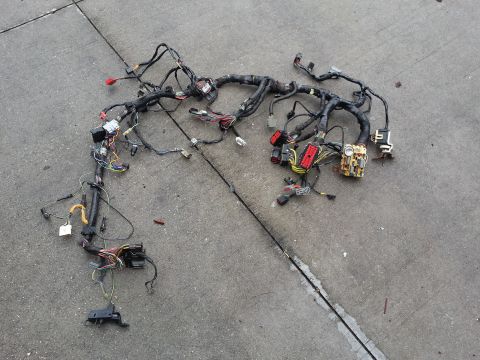 1994 Ford Bronco - A complex automotive wiring harness is spread out on a concrete surface, showing numerous wires and electrical connectors.