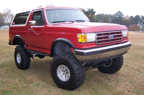 1990 Ford Bronco - This lifted 1990 Ford Bronco features a prominent chrome grille and aggressive off-road tires.