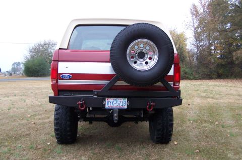 1990 Ford Bronco - Rear view of a red 1990 Ford Bronco a spare tire on a swing-away carrier and a custom rear bumper.