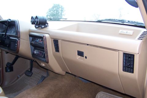 1990 Ford Bronco - The interior shows an aftermarket radio and dual gauges above the dashboard, with an 'Eddie Bauer' badge visible.