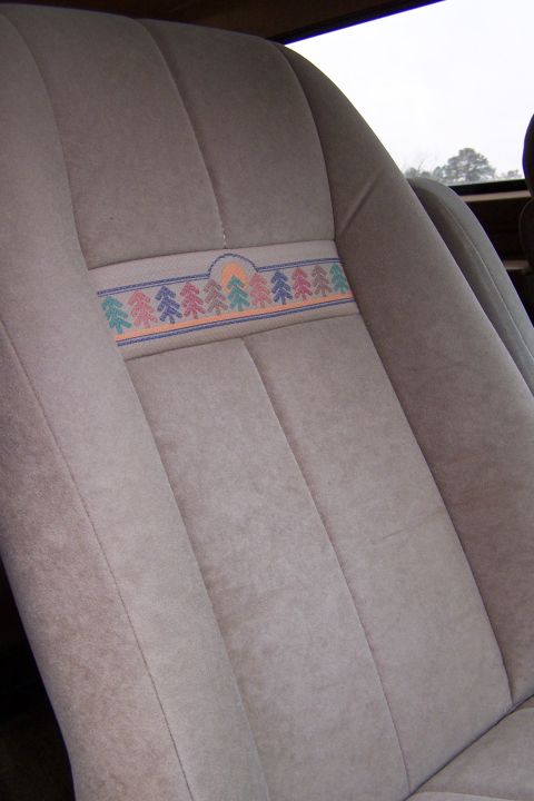 1990 Ford Bronco - Car seat upholstery with a decorative band showing trees and a sun motif.