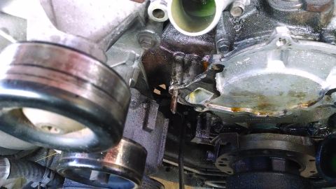 1995 Ford Bronco - Close-up view of engine components showing pulleys and evidence of a coolant leak.