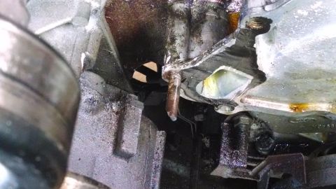 1995 Ford Bronco - Engine part showing signs of oil leakage and corrosion.