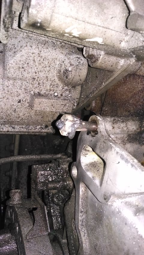 1995 Ford Bronco - Close-up view of a greasy engine component with visible bolt and bracket detail.