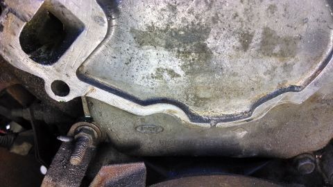 1995 Ford Bronco - Close-up of a Ford emblem on an engine component, likely from a 1995 Ford Bronco.