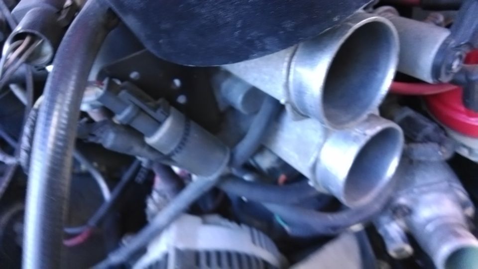 Close-up of engine's throttle body with two intake pipes