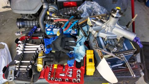 1995 Ford Bronco - Tools and a new water pump are laid out in preparation for engine work.