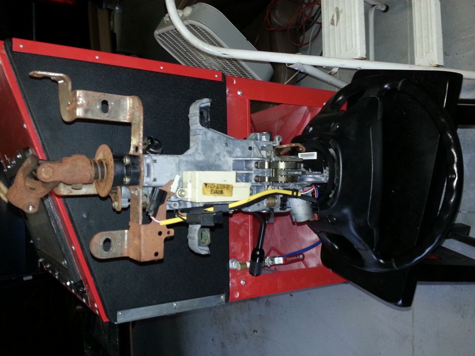 Vehicle steering column assembly with ignition and wiring, mounted in a red frame
