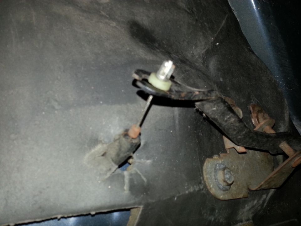 Close-up of a cable mechanism with a bulb and bracket, possibly from a vehicle interior