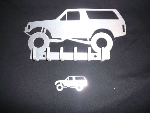 1988 Ford Bronco - This metal wall art features a silhouette of a lifted Bronco with hooks, alongside a smaller Bronco silhouette.